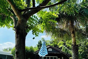 Une maison avec un arbre au premier plan et un ciel dégagé en arrière-plan.