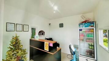 A reception area with a reception desk, a Christmas tree, and a refrigerator.