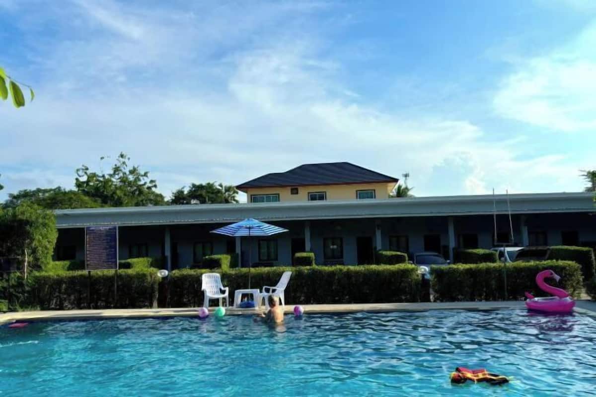 Una piscina con lettini e un gonfiabile a forma di fenicottero.