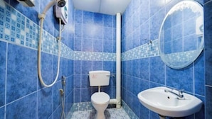 Un bagno con piastrelle blu, un water, un lavandino e uno specchio.