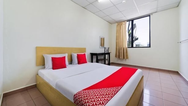 Una habitación de hotel con cama, escritorio y ventana.