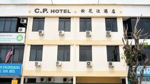 Un edificio de hotel con múltiples unidades de aire acondicionado, un cartel que dice C.P. HOTEL y un cartel de una empresa de ingeniería.