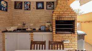 Una cocina con horno de ladrillo, armarios blancos y obras de arte en la pared.