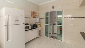 Una cocina compacta equipada con refrigerador, microondas, tostadora y un lavamanos pequeño.
