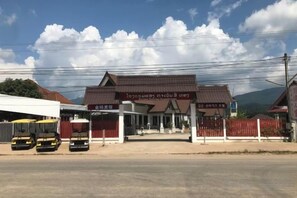 A building with a sign indicating a business or service area, a covered entrance, and a fenced perimeter.
