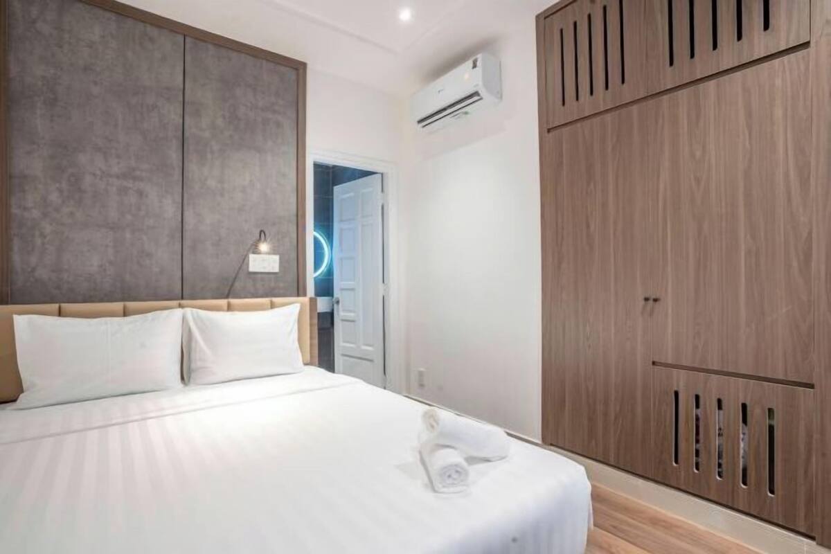 Ein Schlafzimmer mit einem Bett, einem Nachttisch, einer Wand-Klimaanlage und einem Kleiderschrank.