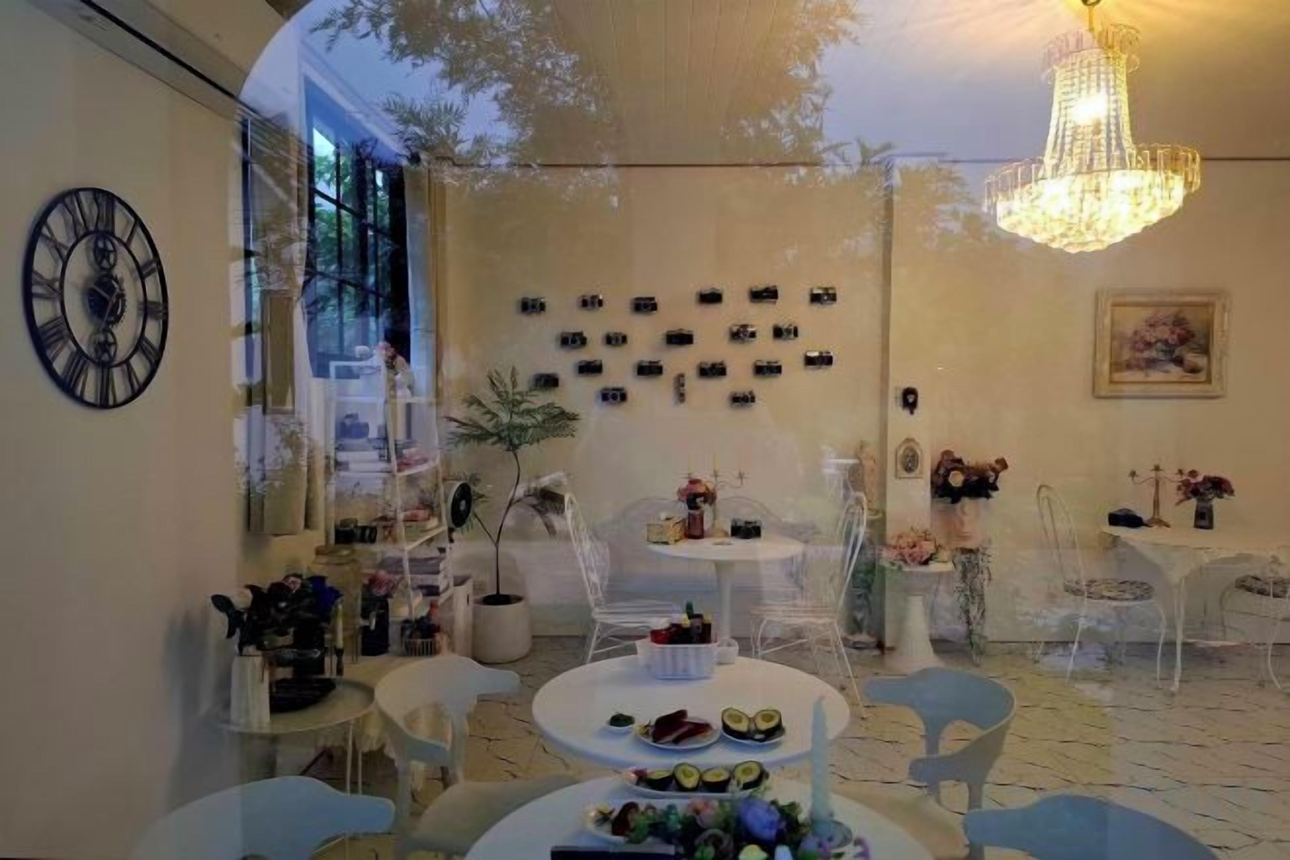 A dining area with round tables, chairs, a chandelier, and wall-mounted decorations.