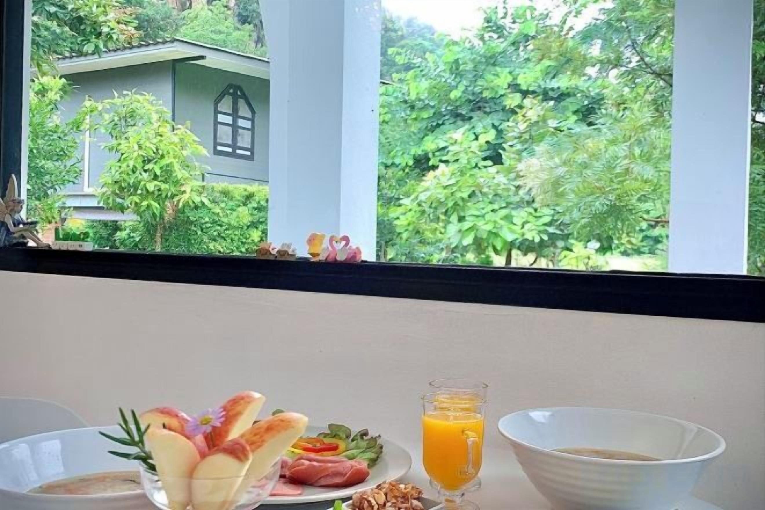 A breakfast table with a plate of food, a glass of orange juice, and a bowl.
