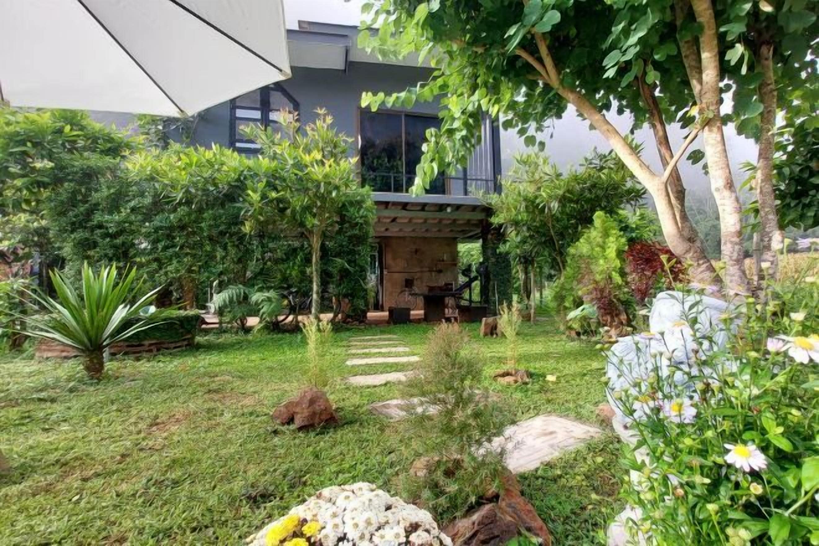 A modern house with a well-maintained garden, a patio area, and a stone pathway.