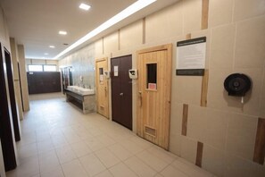 Un couloir comportant plusieurs toilettes, chacune étant équipée d’un lavabo et d’un miroir.