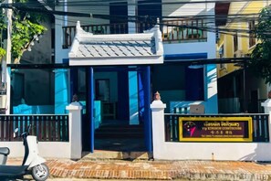 A building with a traditional architectural style, a signboard, and a scooter parked in front. - Vip Kingson Guest House (Luang Prabang)
