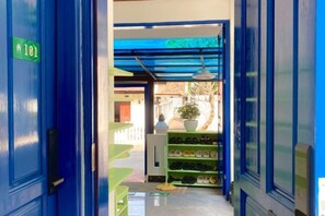 A hallway with a blue door marked '101' leading to a room with a blue ceiling and a plant. - Vip Kingson Guest House (Luang Prabang)