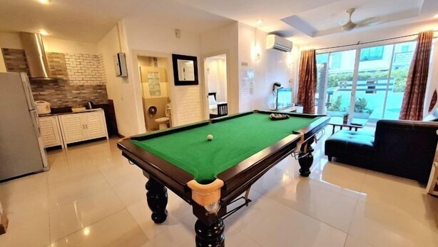 A pool table in a well-lit room with a kitchen area, a seating area, and large windows. - Plus2 Hua-Hin Private Pool Villa from beach 3 km (Hua Hin)