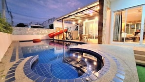 A swimming pool with a slide, a covered patio area, and a building entrance. - Plus2 Hua-Hin Private Pool Villa from beach 3 km (Hua Hin)