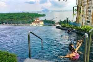 A swimming pool with a view of a body of water and buildings in the background. - Ocean Home@Urban Suites@3BR@10+2 Pax (Jelutong)