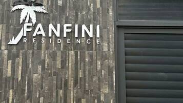 Ein Gebäude mit einem Schild, das 'FANFINI RESIDENCE' zeigt, und einem Palmenlogo.