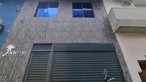 A building facade with a 'PANFINI RESIDENCE' sign, two windows, and a closed shutter. - Fanfini Residence Male’ City (Malé)