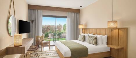A modern hotel room with a large bed, a TV, a desk with a chair, and a view of the outdoors.