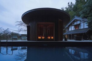 A modern building with a circular structure and a pool in front. - RICKA KATSUURA (Katsuura)