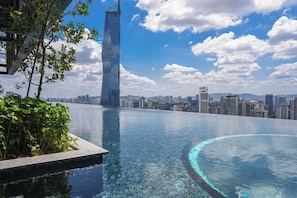 A rooftop infinity pool with a city skyline view, including a prominent skyscraper. - Lucentia Residence by Glory Home (Kuala Lumpur)