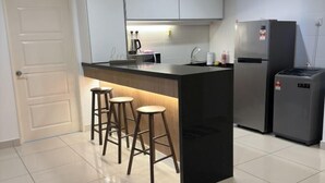 A modern kitchen with a central island, bar stools, a refrigerator, and a sink. - HappySty in George Town Amazing sea view (George Town)
