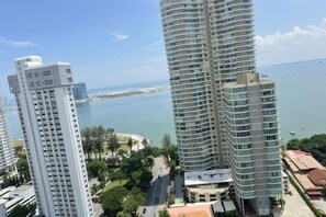 A high-rise building with a curved facade overlooking a body of water. - HappySty in George Town Amazing sea view (George Town)