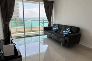 A living room with a sofa, a glass table, and a view of the ocean. - HappySty in George Town Amazing sea view (George Town)