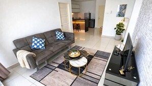 A modern living room with a sofa, coffee table, and TV stand. - HappySty in George Town Amazing sea view (George Town)