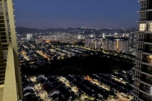 A high-rise building with multiple floors, a parking area, and a densely populated urban area in the background. - Elevated Cozy Homestay @Heart of Sri Petaling 3R3B (Kuala Lumpur)