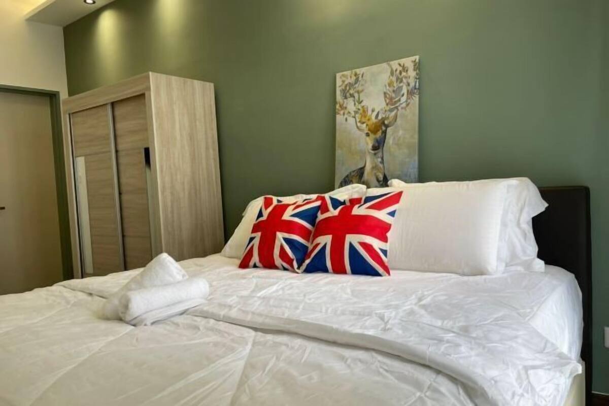 Ein Bett mit weißer Bettwäsche, ein Reh-Gemälde und ein Kleiderschrank.