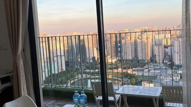 A balcony with a table, chairs, and bottled water. - Luxury Apartment in Vinhomes D'Capitale by David Home (Hanoi)