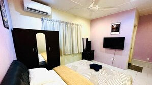 Een slaapkamer met een bed, een kledingkast, een televisie en een spiegel.