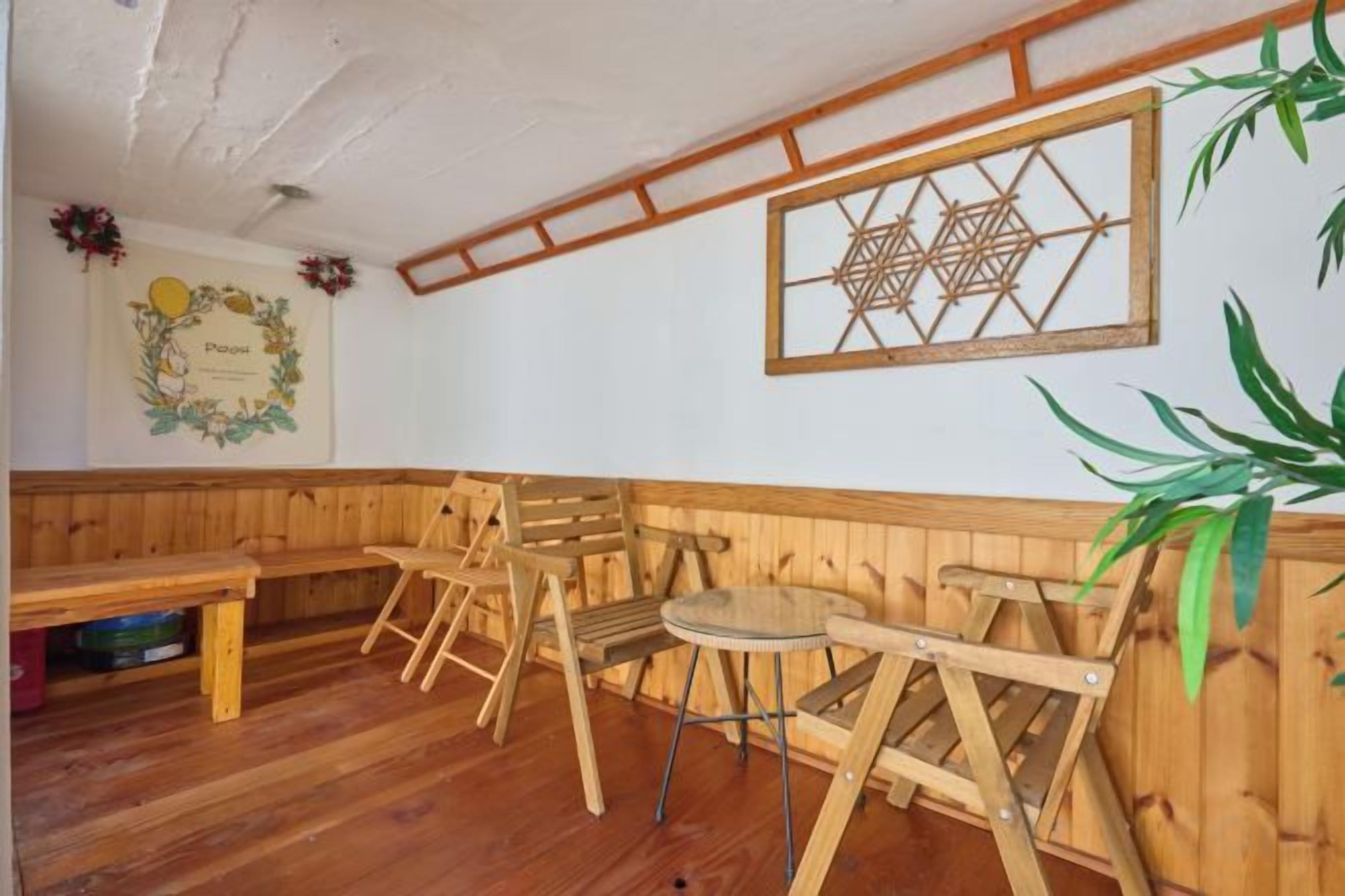 A wooden interior with a bench, tables, and a wall decoration.