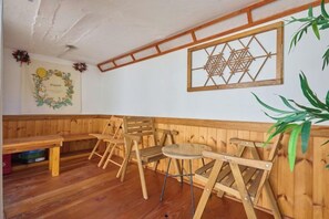 A wooden interior with a bench, tables, and a wall decoration. - Traditional House Hotel Andong Villa (Andong-si)