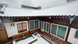 A traditional Japanese-style building with a tiled roof, wooden exterior, and large windows. - Traditional House Hotel Andong Villa (Andong-si)