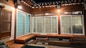 A traditional Japanese onsen with wooden architecture, large sliding doors, and a stone hot spring area. - Traditional House Hotel Andong Villa (Andong-si)