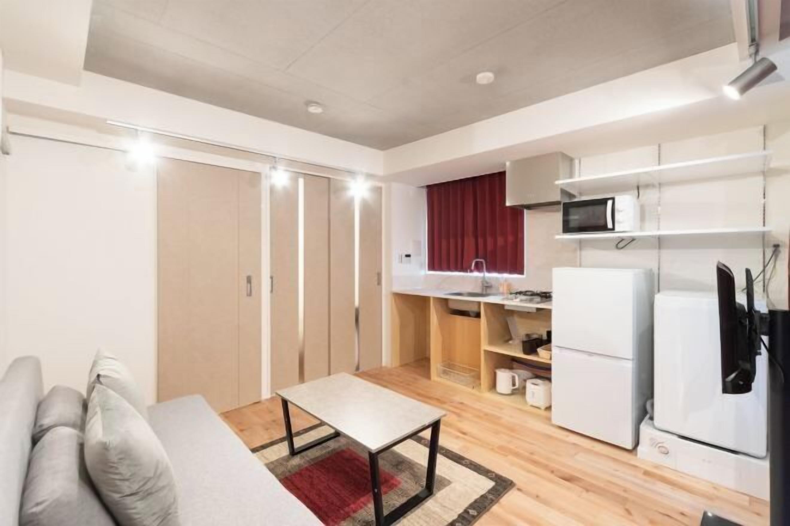 A compact kitchen with a microwave, refrigerator, and a small dining area.