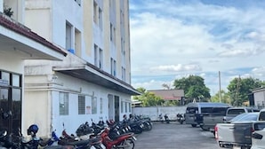 A parking lot with several motorcycles and cars parked in front of a building with multiple windows and balconies. - ST Residence@Rayong (Pluak Daeng)