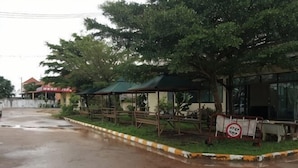 A covered outdoor seating area with tables and chairs, a 'No Parking' sign, and a building in the background. - ST Residence@Rayong (Pluak Daeng)