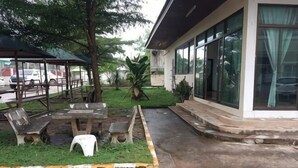 A patio area with outdoor seating, a small table, and a tree. - ST Residence@Rayong (Pluak Daeng)