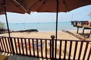 On peut admirer la plage depuis un espace abrité doté d’une rambarde, qui offre une vue sur une plage de sable et une jetée avec un poste de surveillance pour les sauveteurs.