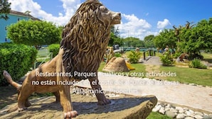 A lion statue in a landscaped garden with a pathway and greenery. - Sosua Ocean Village, Villas 24 (Sosúa)