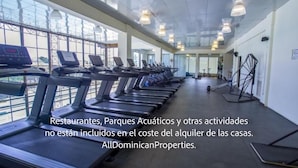A gym with treadmills and exercise equipment, large windows, and a ceiling with hanging lights. - Sosua Ocean Village, Villas 24 (Sosúa)