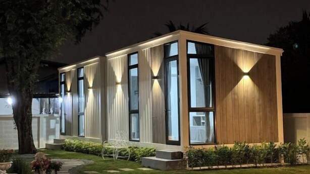 Un bâtiment moderne à deux étages, doté de grandes fenêtres et d’une façade en bois.