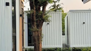 Un bâtiment moderne doté de grandes fenêtres et d’un arbre au centre.