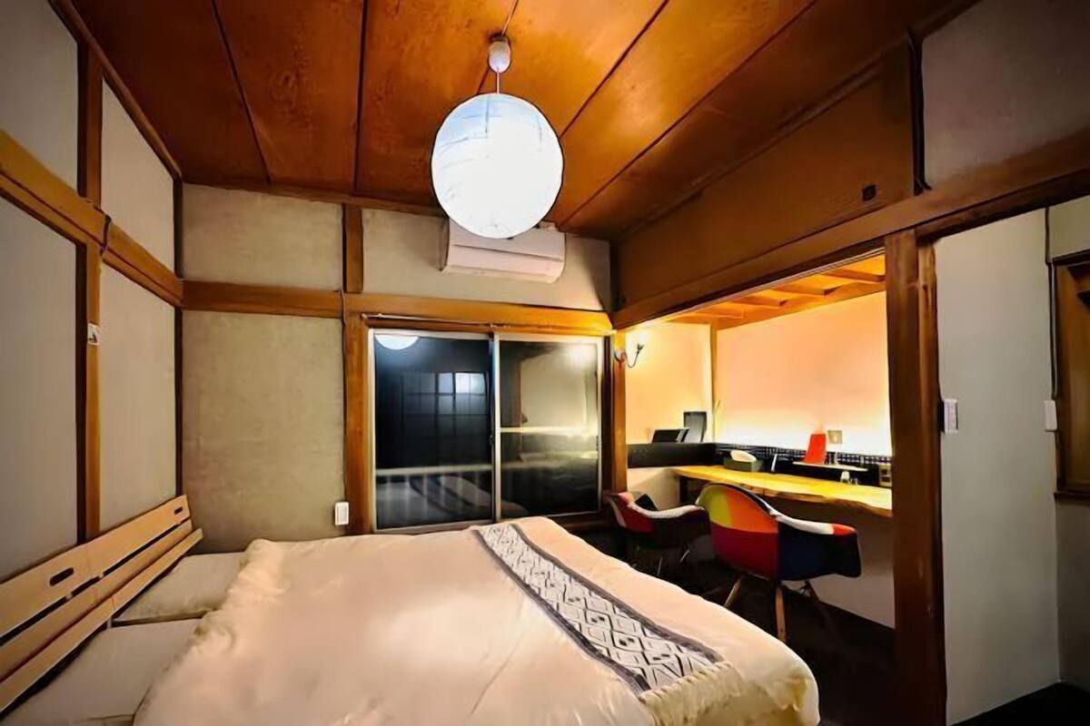 A room with a bed, a desk, and a chair.