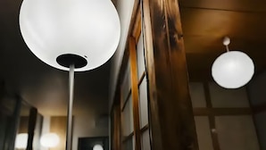 A corridor with wooden walls and a ceiling light fixture.