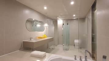 A modern bathroom with a bathtub, a sink, a mirror, and a glass shower enclosure.