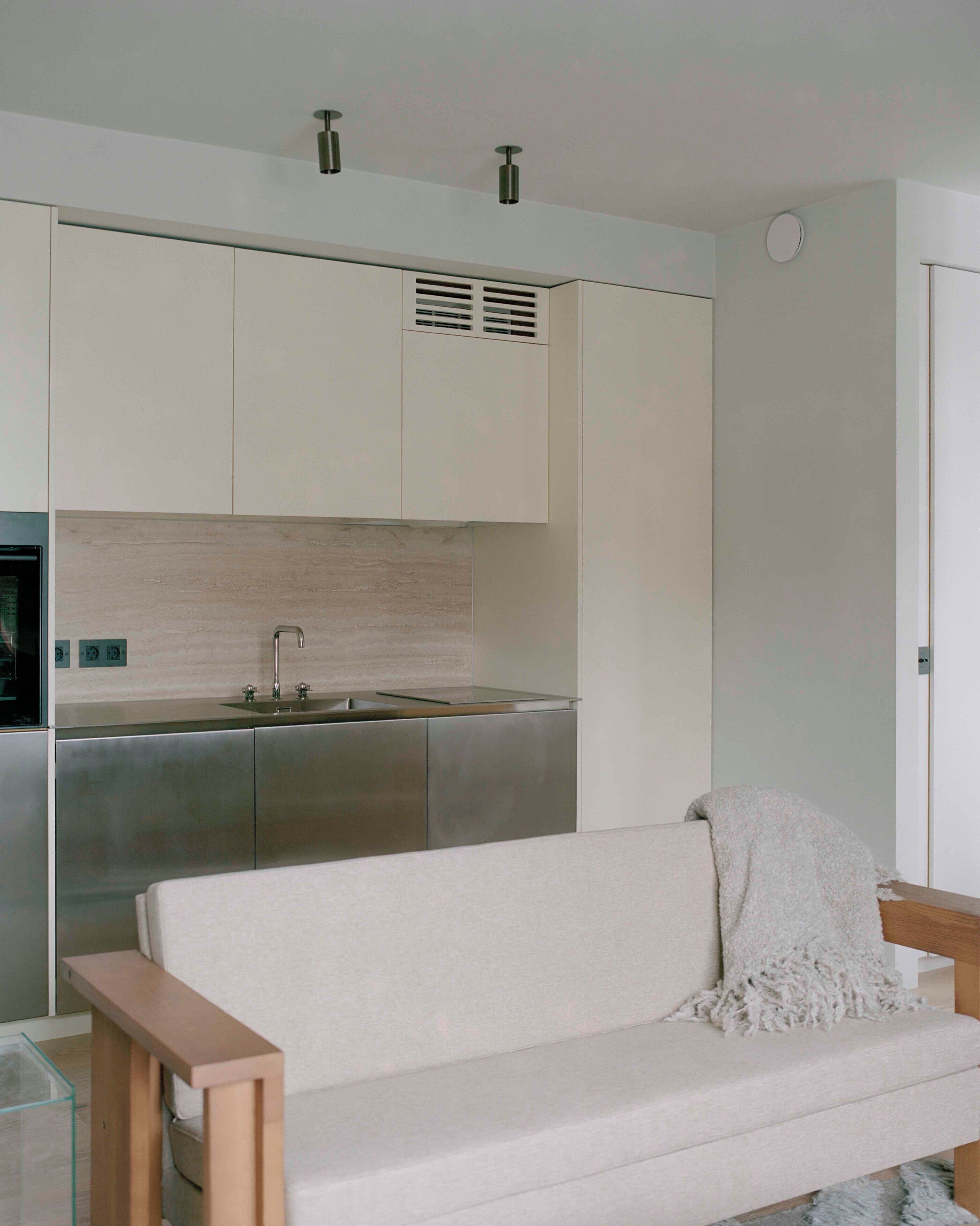 A modern kitchen with stainless steel appliances, a built-in sink, and a white countertop.