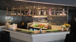 Eine Bar mit Theke, Regalen und verschiedenen Barutensilien.